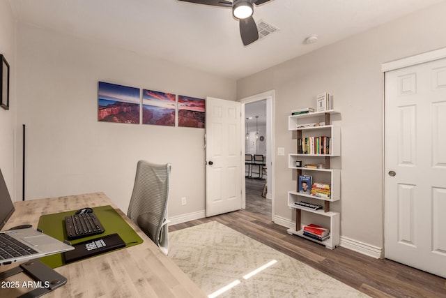 home office with dark wood-type flooring and ceiling fan