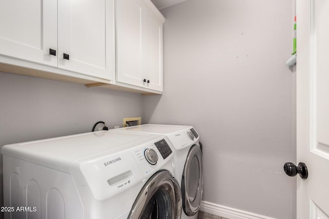 laundry room with cabinets and washer and clothes dryer