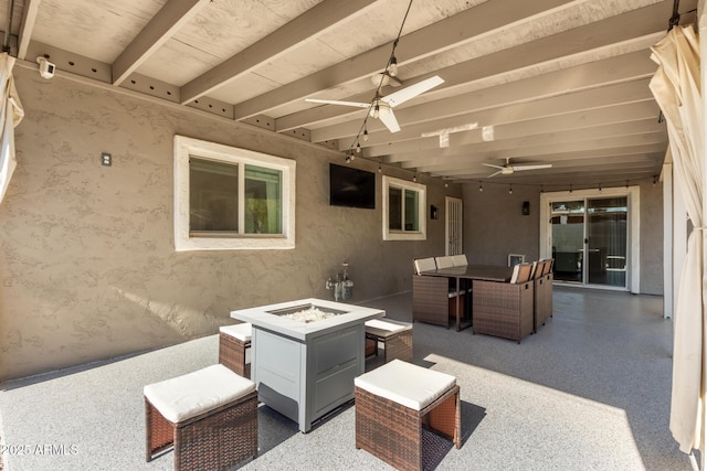 view of patio with ceiling fan and an outdoor fire pit