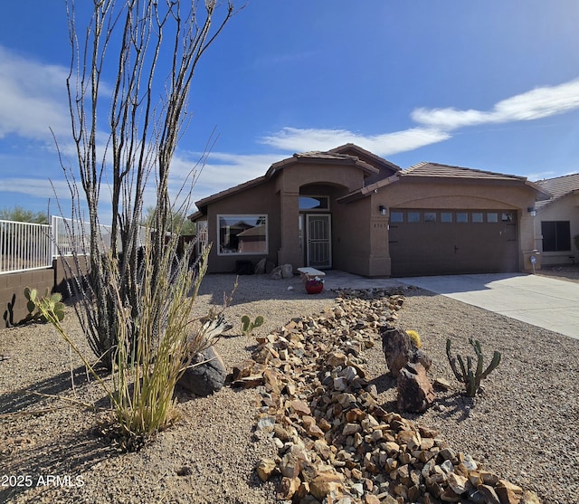 view of front of home featuring stucco siding, concrete driveway, an attached garage, and a tile roof