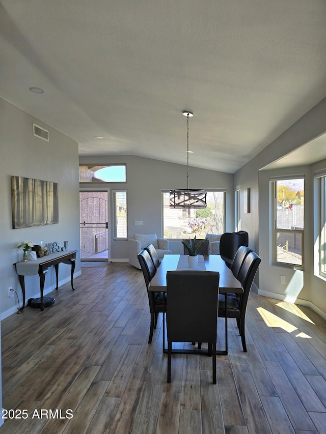 dining area featuring dark wood-style floors, visible vents, plenty of natural light, and vaulted ceiling