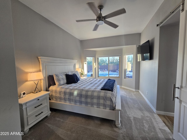 bedroom featuring a barn door, a ceiling fan, and baseboards