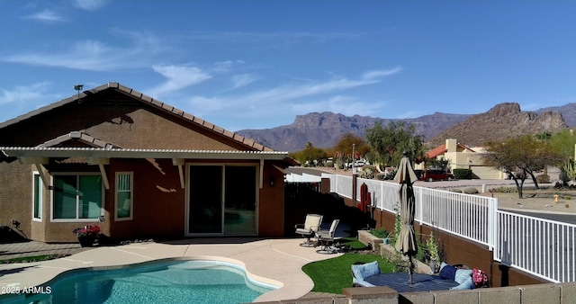 exterior space with a fenced in pool, fence, a tile roof, a patio area, and a mountain view