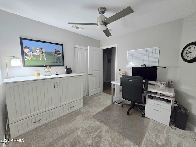 home office with ceiling fan, visible vents, and light carpet