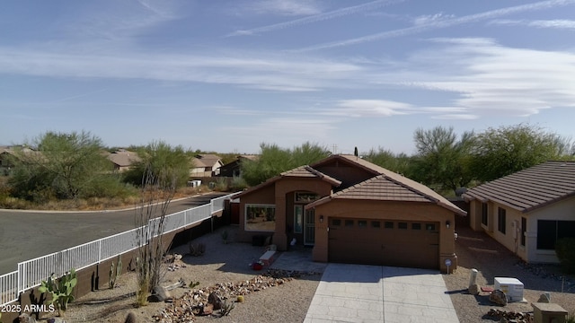 ranch-style home with fence, driveway, an attached garage, stucco siding, and a tiled roof