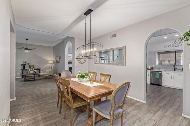 1231 W Mediterranean Dr, Gilbert, AZ 85233 - dining area with arched walkways, wood finished floors, baseboards, and a ceiling fan