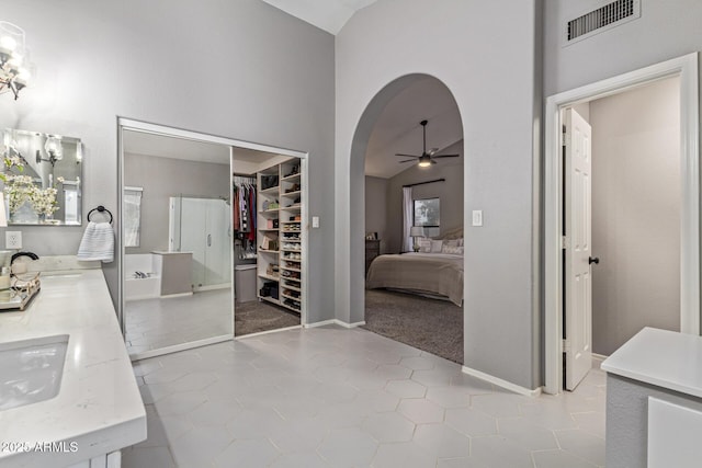 1231 W Mediterranean Dr, Gilbert, AZ 85233 - full bathroom with high vaulted ceiling, a ceiling fan, connected bathroom, double vanity, and tile patterned floors