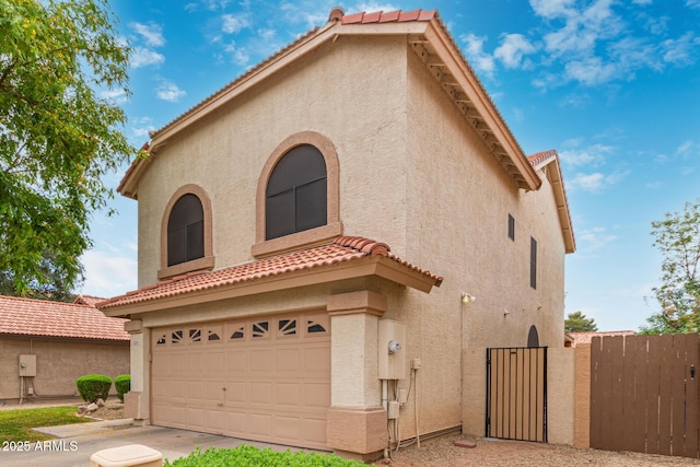 1231 W Mediterranean Dr, Gilbert, AZ 85233 - mediterranean / spanish house with stucco siding, a garage, a gate, and a tile roof