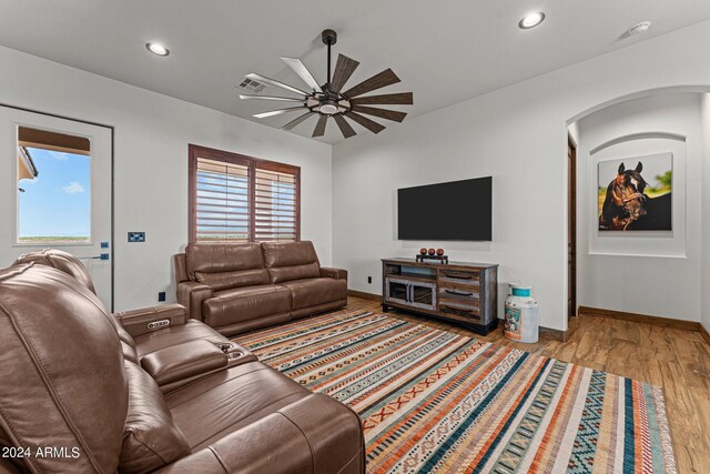 living room with plenty of natural light, ceiling fan, and light wood-type flooring