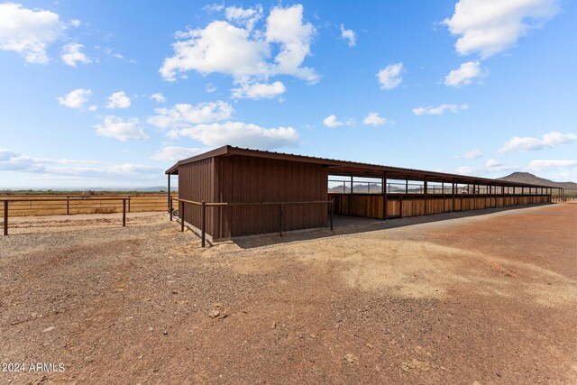 view of horse barn with an outbuilding and a rural view