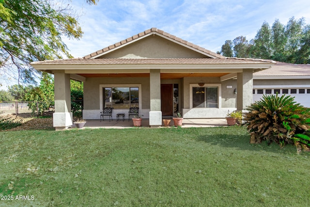 view of front of home with a garage, a front lawn, and a patio