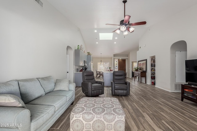 living room with wood-type flooring, ceiling fan, and high vaulted ceiling