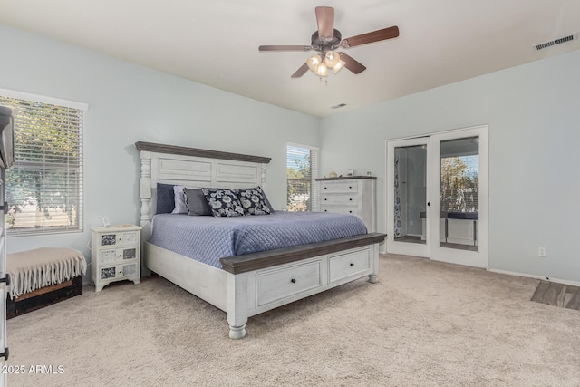 bedroom with multiple windows, access to outside, light colored carpet, and ceiling fan