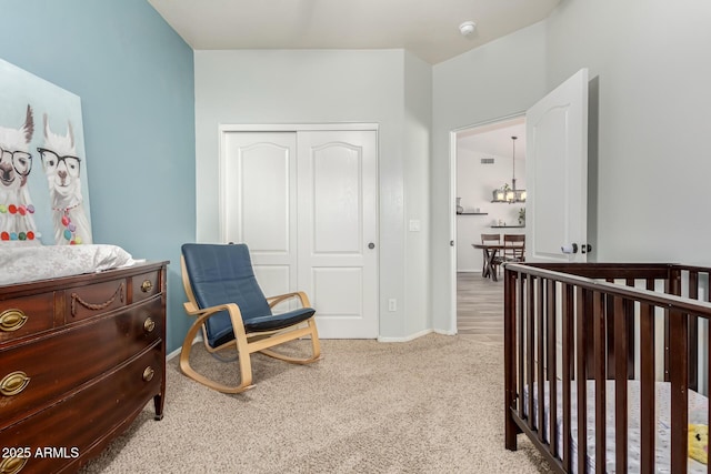 bedroom with a nursery area, light carpet, and a closet