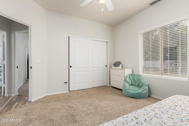 bedroom featuring light carpet, ceiling fan, and a closet