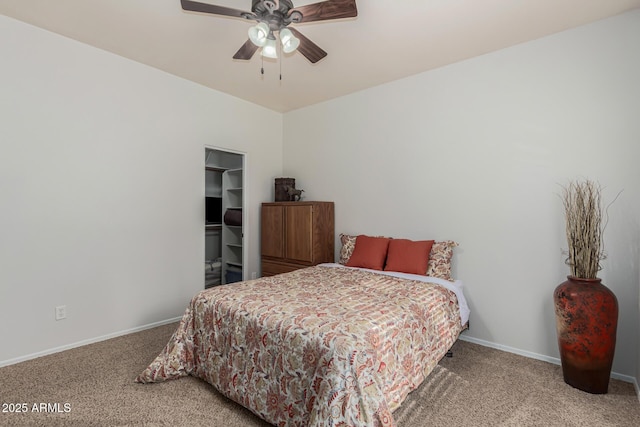 carpeted bedroom featuring a spacious closet and ceiling fan