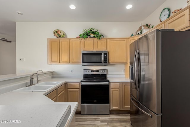 kitchen with stainless steel appliances, kitchen peninsula, sink, and light brown cabinets