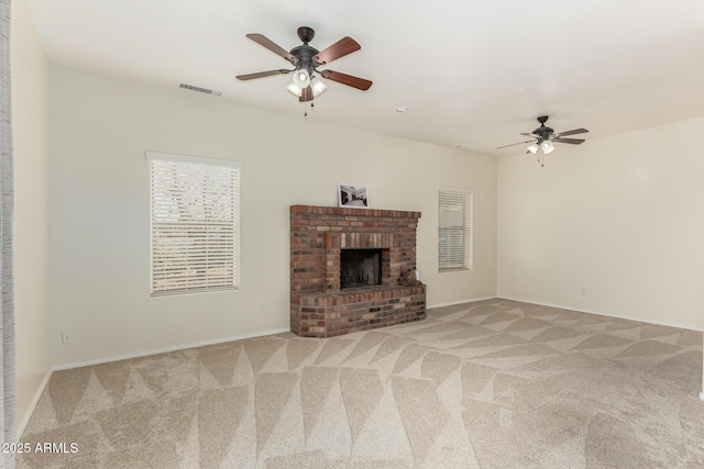 unfurnished living room featuring ceiling fan, a fireplace, and light carpet