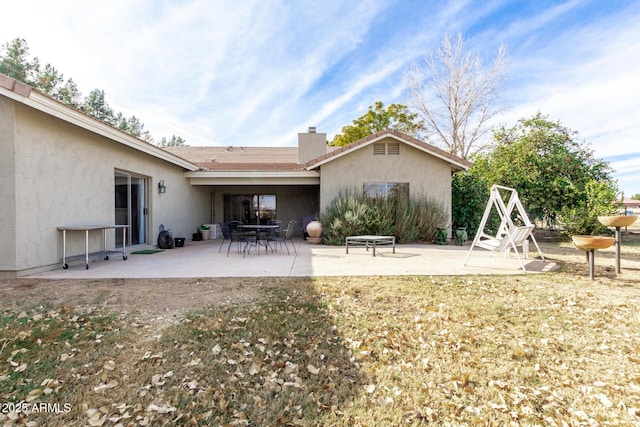 back of house featuring a patio and a lawn