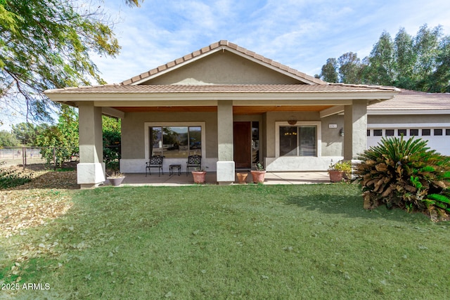 view of front facade with a garage, a front yard, and a patio area