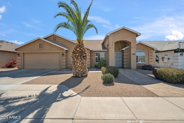 view of front facade featuring a garage, concrete driveway, and stucco siding