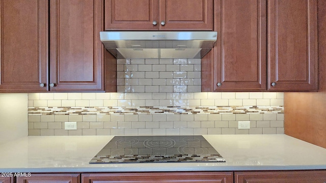 kitchen with ventilation hood, decorative backsplash, light stone countertops, and black cooktop