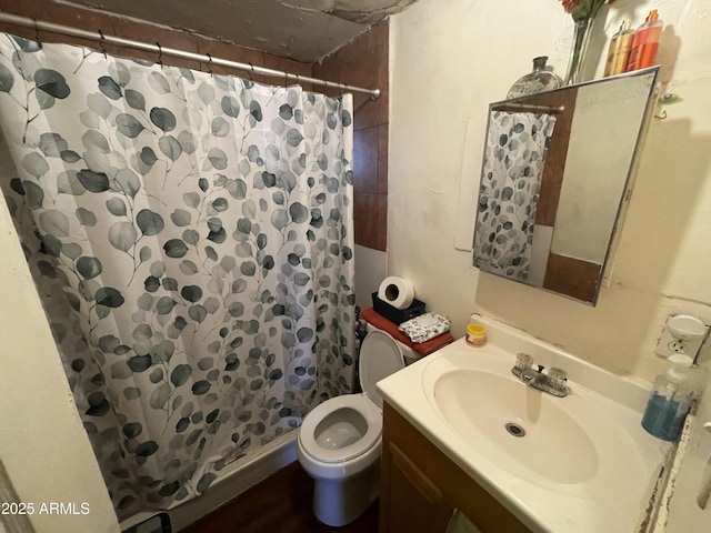 bathroom with toilet, vanity, and a shower stall