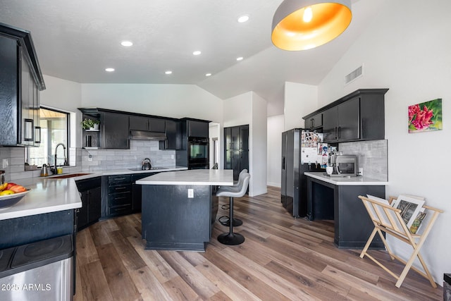 15261 E Golden Eagle Blvd, Fountain Hills, AZ 85268 - kitchen featuring a center island, stainless steel fridge, a breakfast bar area, open shelves, and decorative backsplash