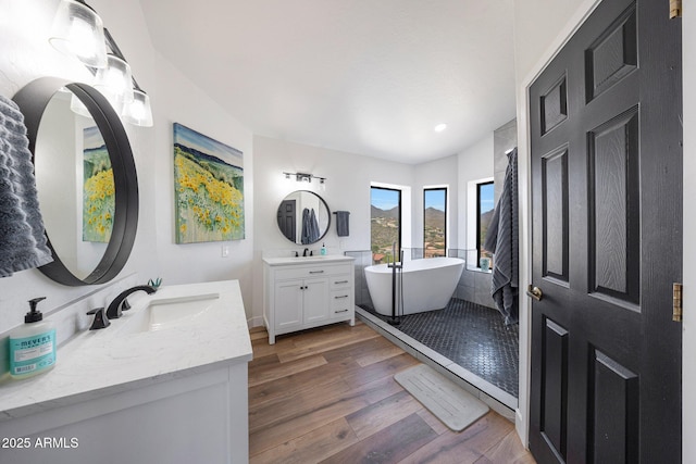 15261 E Golden Eagle Blvd, Fountain Hills, AZ 85268 - bathroom featuring two vanities, wood finished floors, a freestanding tub, and recessed lighting