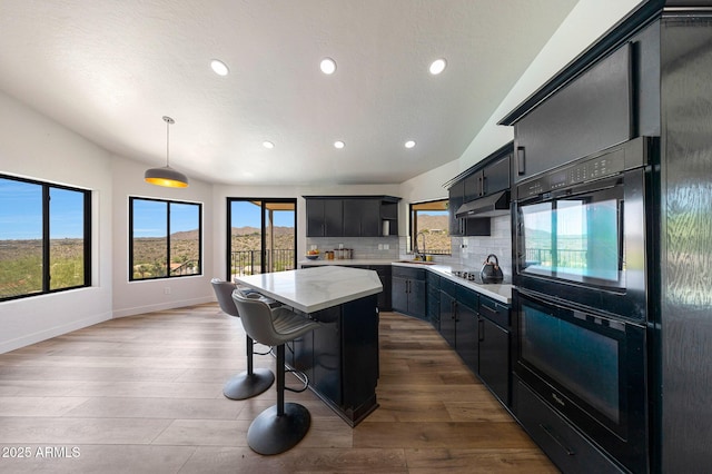 15261 E Golden Eagle Blvd, Fountain Hills, AZ 85268 - kitchen with black appliances, a kitchen island, under cabinet range hood, light countertops, and recessed lighting