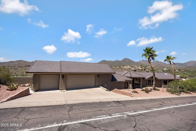 15261 E Golden Eagle Blvd, Fountain Hills, AZ 85268 - view of front of house featuring a mountain view, an attached garage, driveway, stucco siding, and a tile roof