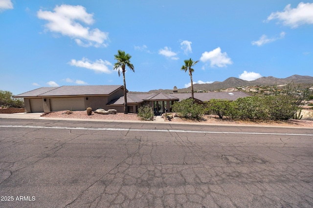 15261 E Golden Eagle Blvd, Fountain Hills, AZ 85268 - ranch-style house featuring a mountain view, a garage, stucco siding, and driveway