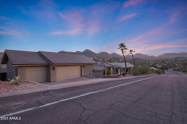 15261 E Golden Eagle Blvd, Fountain Hills, AZ 85268 - view of front facade with an attached garage, stucco siding, a mountain view, a tiled roof, and concrete driveway