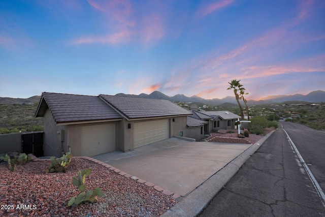 15261 E Golden Eagle Blvd, Fountain Hills, AZ 85268 - view of front of house featuring a mountain view, a garage, stucco siding, concrete driveway, and a tiled roof
