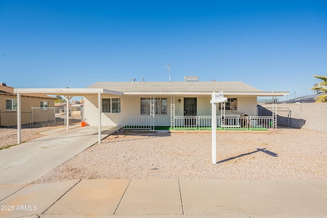 view of front of property featuring a porch, an attached carport, and fence