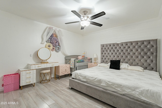 bedroom with ornamental molding, wood finished floors, and a ceiling fan