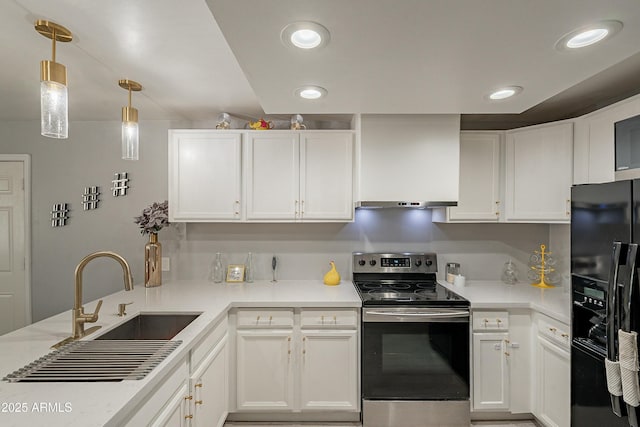 kitchen featuring electric stove, black fridge, and light countertops