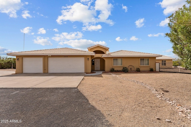 1216 Easy St, Wickenburg, AZ 85390 - view of front of home featuring concrete driveway, stucco siding, a garage, and a tiled roof