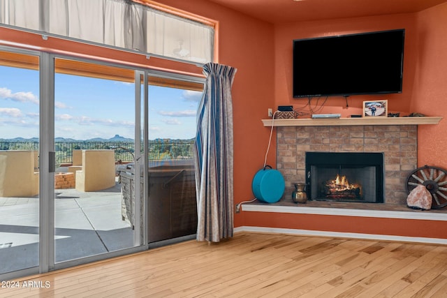 1216 Easy St, Wickenburg, AZ 85390 - living room featuring wood finished floors, a warm lit fireplace, and baseboards