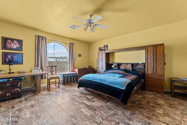 bedroom with ceiling fan and a textured ceiling