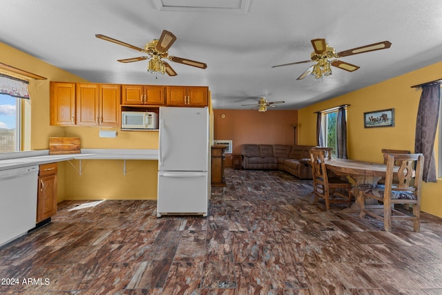 kitchen featuring dark hardwood / wood-style floors, kitchen peninsula, and white appliances