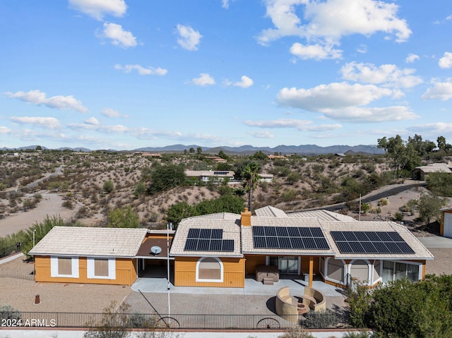 exterior space featuring a patio, a mountain view, and solar panels