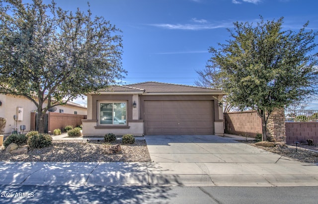 view of front of home with an attached garage, fence, concrete driveway, and stucco siding