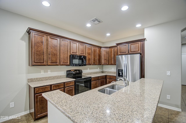 kitchen featuring recessed lighting, a sink, visible vents, black appliances, and an island with sink