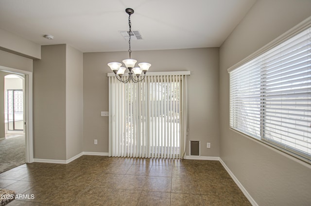 unfurnished room featuring baseboards, visible vents, a chandelier, and a wealth of natural light