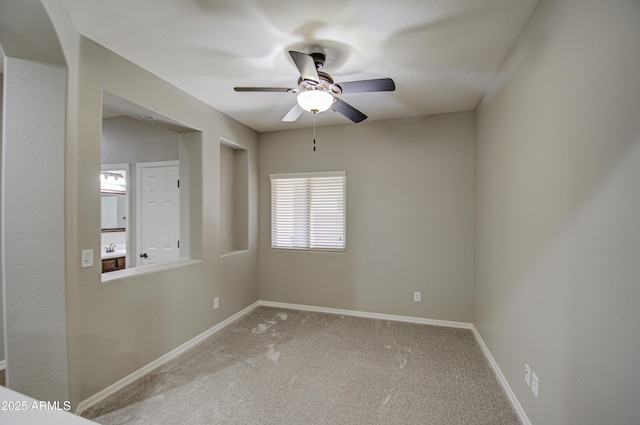 unfurnished room with carpet, baseboards, and a ceiling fan