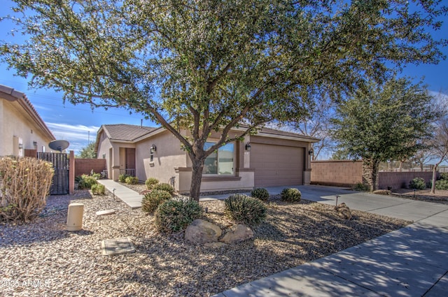 single story home featuring driveway, an attached garage, fence, and stucco siding