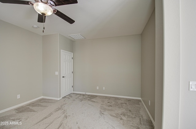 carpeted spare room with a ceiling fan, visible vents, and baseboards