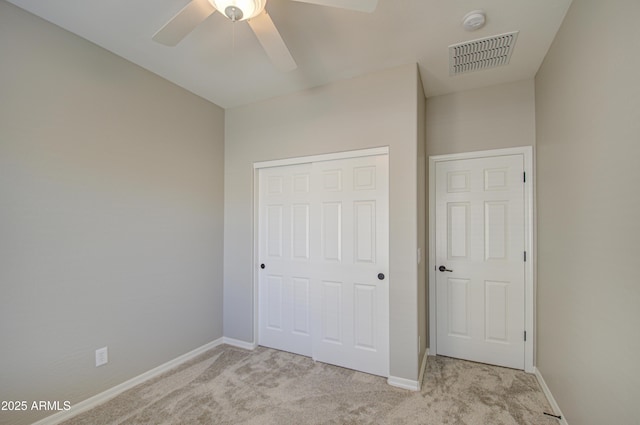 unfurnished bedroom featuring baseboards, visible vents, ceiling fan, carpet, and a closet