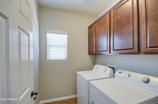 washroom with cabinet space, washer and clothes dryer, and baseboards